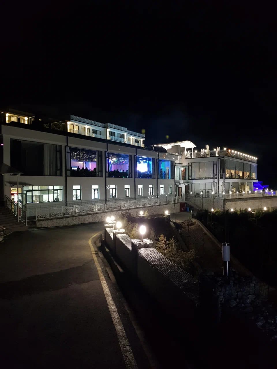 Освещённые залы ресторана и террасы курорта в темноте